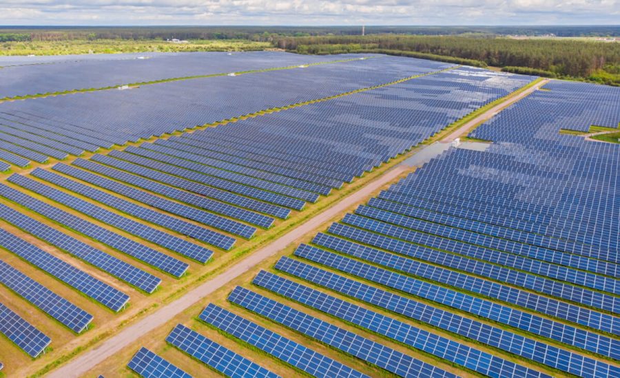 Solar panel produces green, environmentaly friendly energy from the setting sun. Aerial view from drone. Landscape picture of a solar plant that is located inside a valley